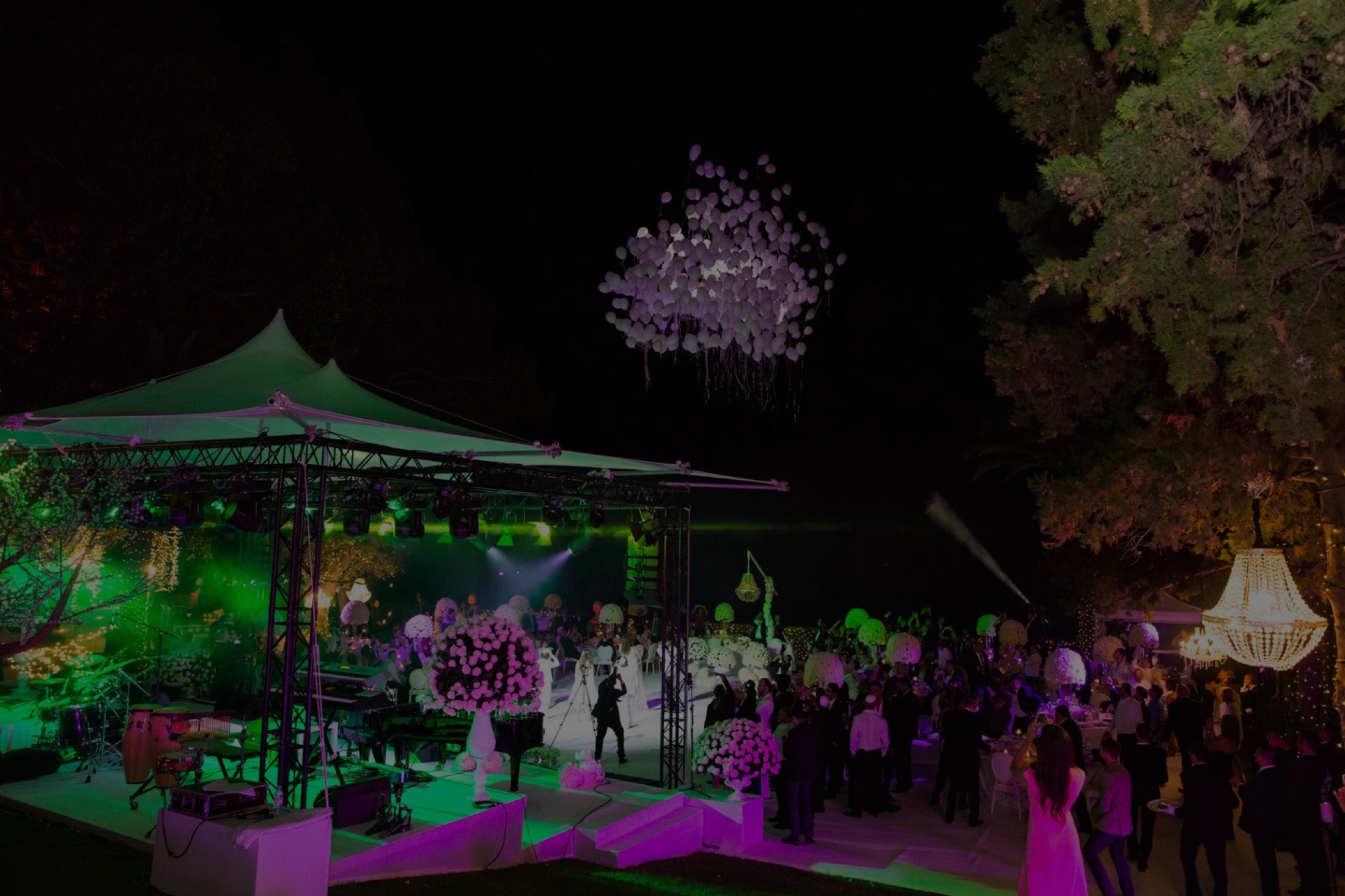 Outdoor corporate event at night with festival lighting and marquee